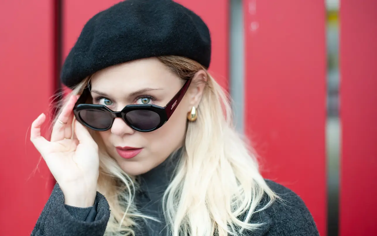 Portrait of woman in editorial fashion style beside red door